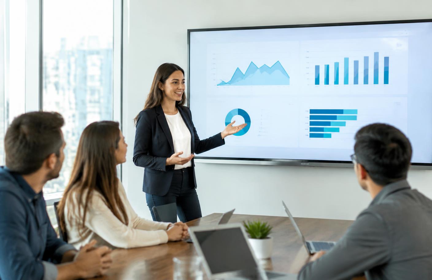 Digital marketing strategist presenting campaign results to a business client in a conference room.